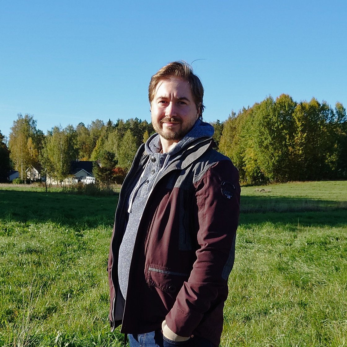 Kuva Lauri Lavannista pellon edustalla. Taaempana taustalla on metsää.