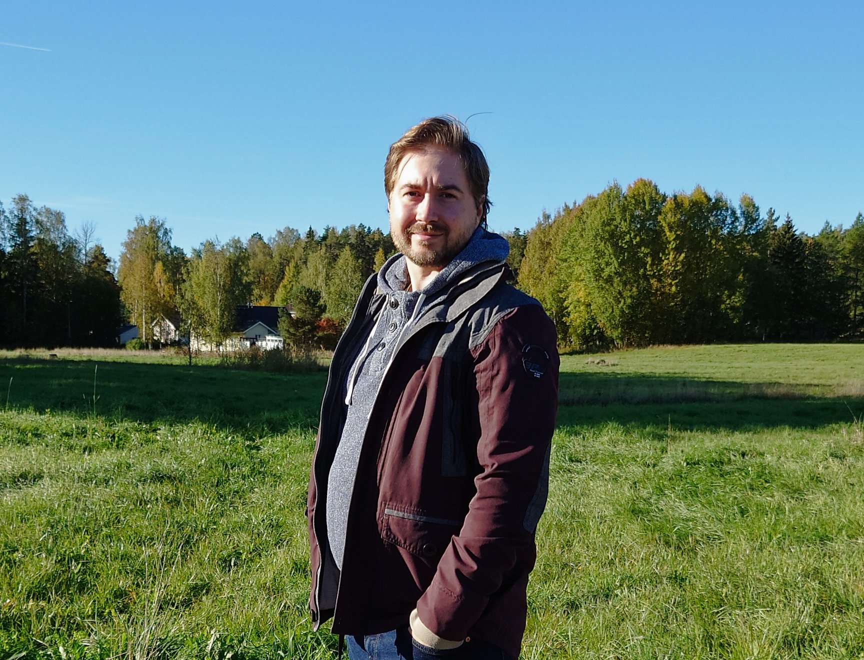 Kuva Lauri Lavannista pellon edustalla. Taaempana taustalla on metsää.