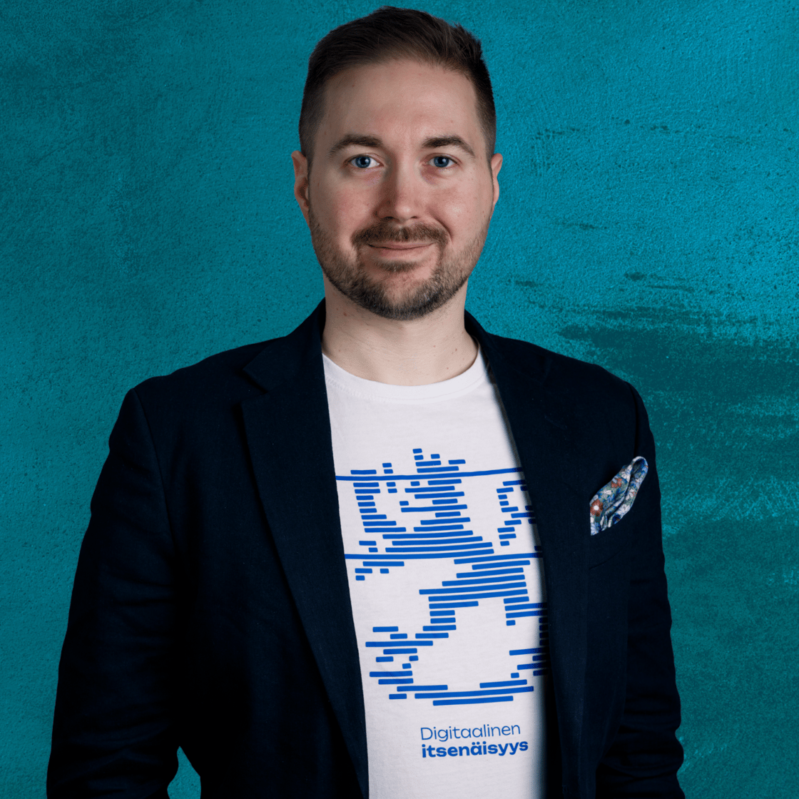 Lauri Lavanti hymyilemässä ja katsomassa kameraan. Päällään hänellä on valkoinen t-paita, jossa lukee Digitaalinen itsenäisyys, jonka yllä on leijonakuvio. Lisäksi pikkutakki. Kuvan ottanut Erkki Laine.