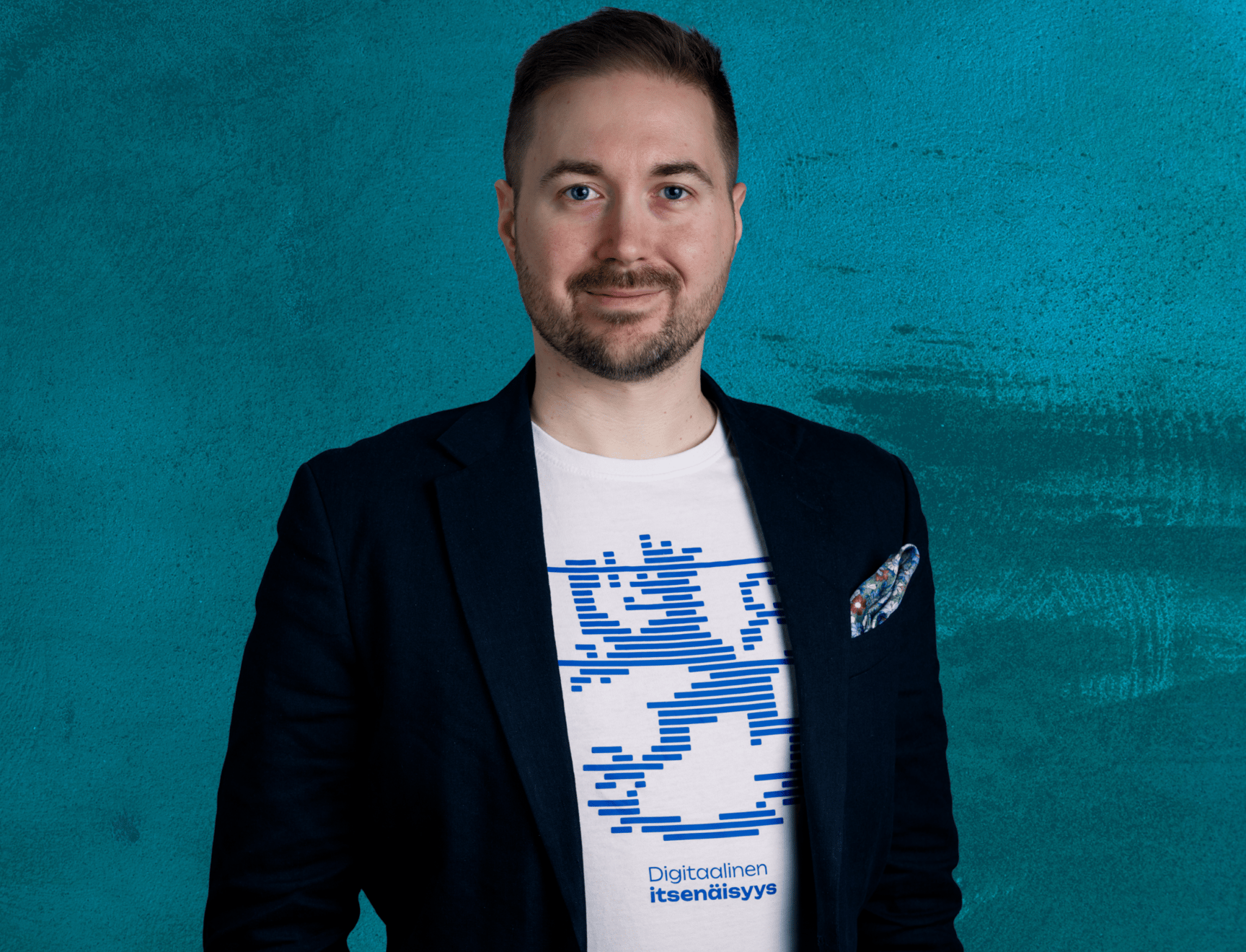 Lauri Lavanti hymyilemässä ja katsomassa kameraan. Päällään hänellä on valkoinen t-paita, jossa lukee Digitaalinen itsenäisyys, jonka yllä on leijonakuvio. Lisäksi pikkutakki. Kuvan ottanut Erkki Laine.
