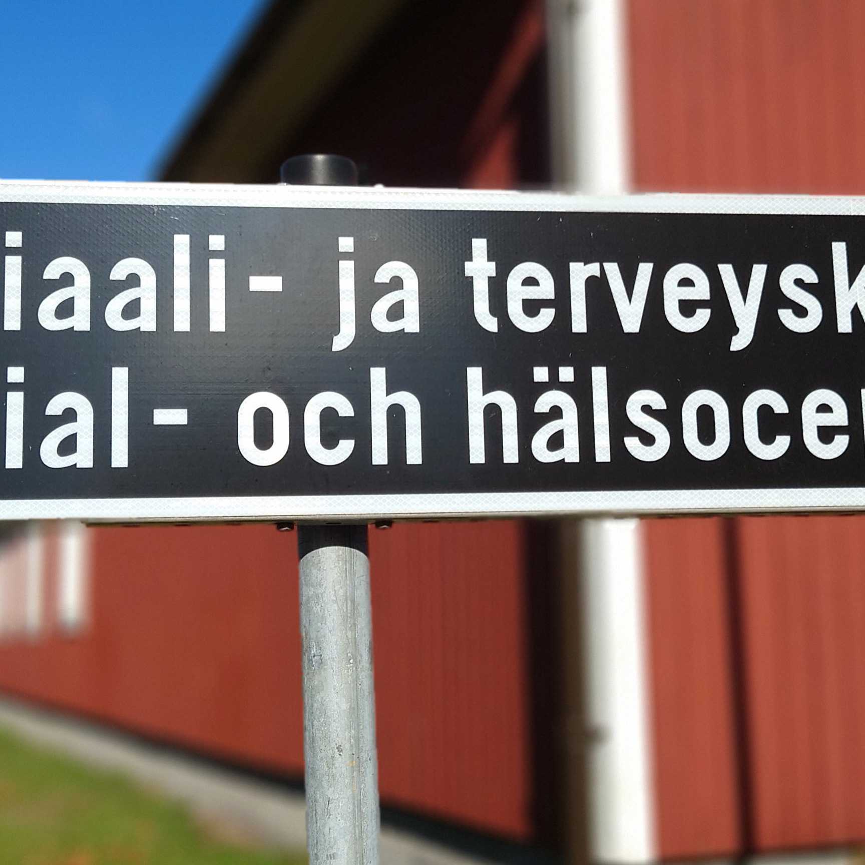 Kuva tiekyltistä, jossa lukee Sosiaali- ja terveyskeskus, sekä sama ruotsiksi alapuolella.